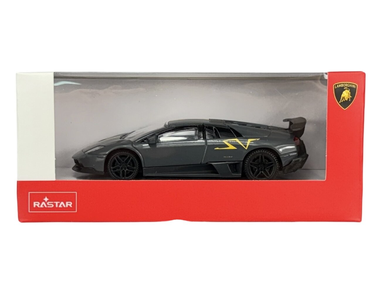 Model samochodu w skali 1:43 w kolorze szarym, umieszczony w czerwonym opakowaniu z przezroczystym frontem. Na opakowaniu widoczne są logotypy \'RASTAR\' i \'Lamborghini\'.