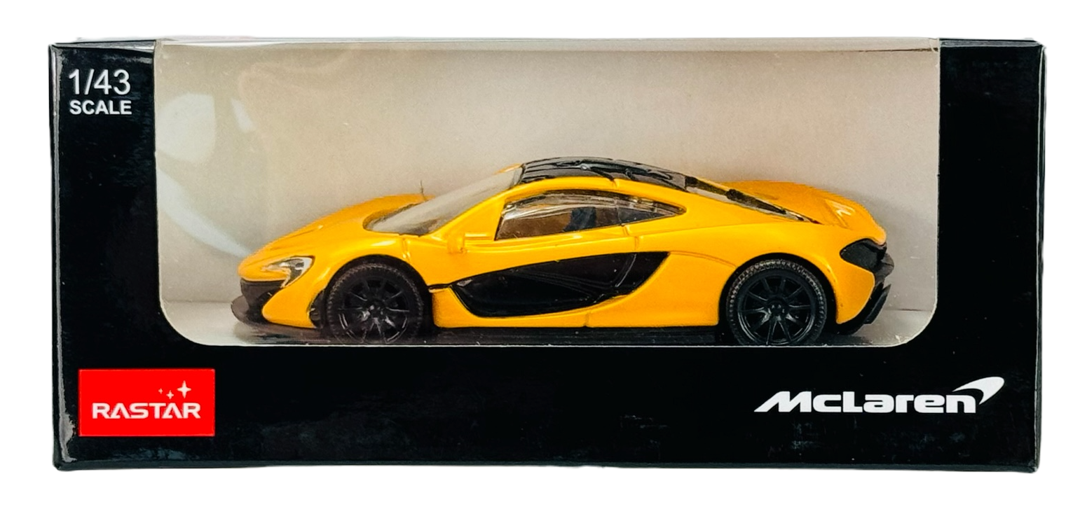 Model samochodu w skali 1/43 w kolorze żółtym znajduje się w pudełku z przezroczystym frontem. Na opakowaniu widoczne są loga \'RASTAR\' i \'McLaren\'.