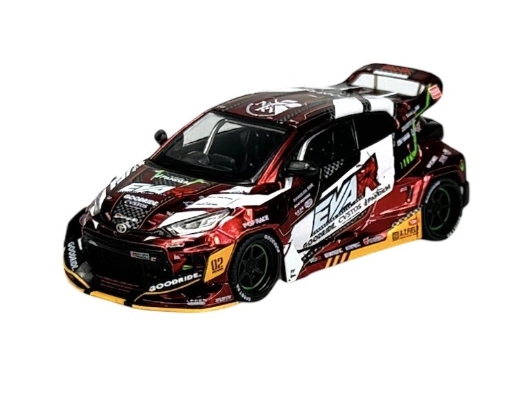 Model samochodu w skali 1:64 z detalami w kolorach czerwonym, białym i czarnym, z widocznymi napisami \'EVA\' i \'GOODRIDE\'. Samochód posiada sportowy design z dużym tylnym spojlerem i licznymi naklejkami sponsorów.