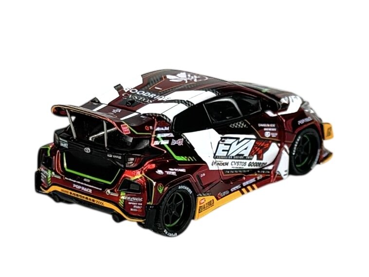 Model samochodu w skali 1:64 z detalami w kolorach czerwonym, białym i czarnym, z widocznymi napisami \'EVA\' oraz różnymi logotypami i wzorami na karoserii.