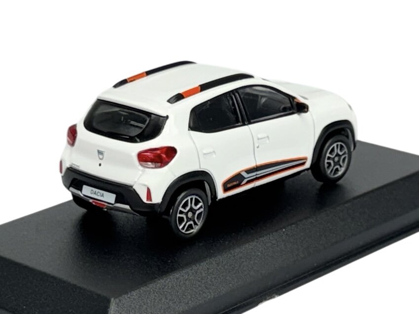 Model samochodu w kolorze białym z czarnymi i pomarańczowymi akcentami, umieszczony na czarnej podstawce. Na tablicy rejestracyjnej widoczny napis \'DACIA\'.