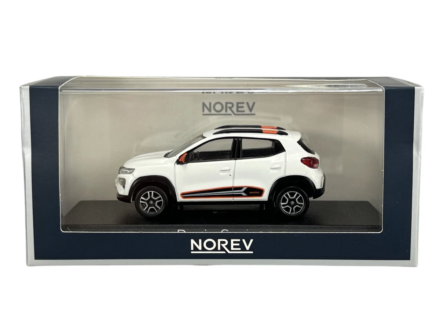Model samochodu w skali 1:43 w kolorze białym, umieszczony w przezroczystym opakowaniu z napisem \'NOREV\'.
