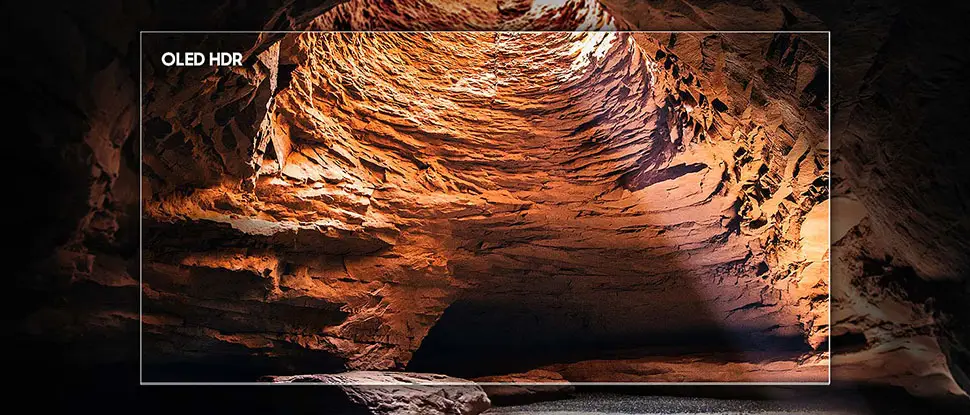 970x415 s85f picture quality oled hdr pc Obraz przedstawia wnętrze jaskini z wyraźnie widocznymi, oświetlonymi ścianami w odcieniach pomarańczowych i brązowych. W lewym górnym rogu widoczny jest napis \'OLED HDR\'.