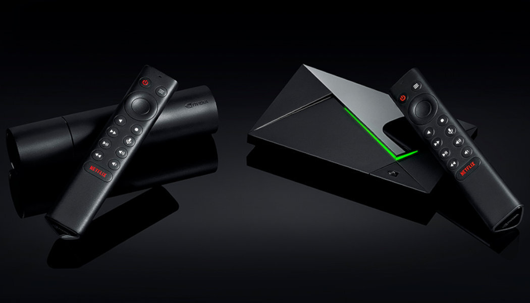 Na ciemnym tle widoczna jest konsola o geometrycznym kształcie z zielonym podświetleniem oraz dwa czarne piloty z czerwonym przyciskiem i napisem \'NETFLIX\'.
