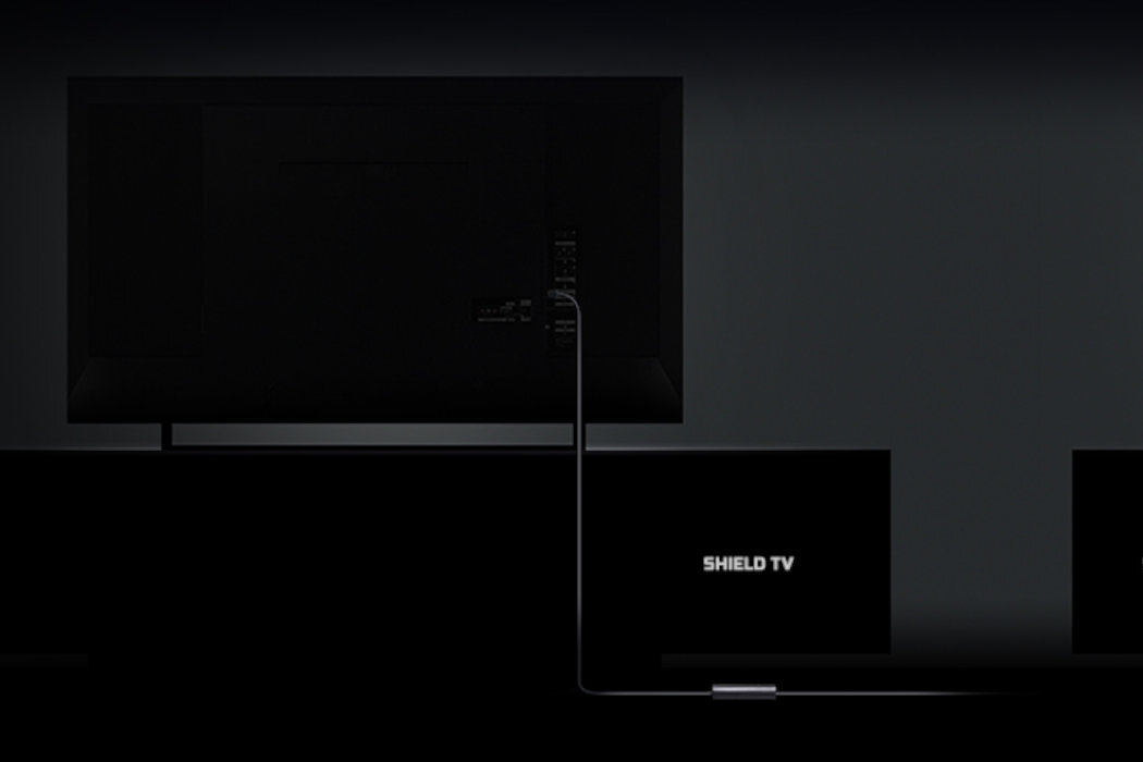 Obraz przedstawia tył telewizora z podłączonym kablem do urządzenia oznaczonego napisem \'SHIELD TV\'.