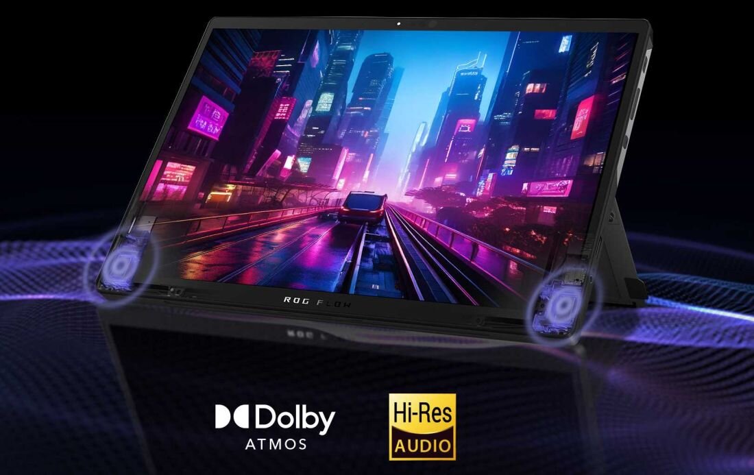 Obraz przedstawia laptop z wyświetlaczem pokazującym futurystyczne miasto nocą. Na dole widoczne są logotypy \'Dolby ATMOS\' i \'Hi-Res AUDIO\'.