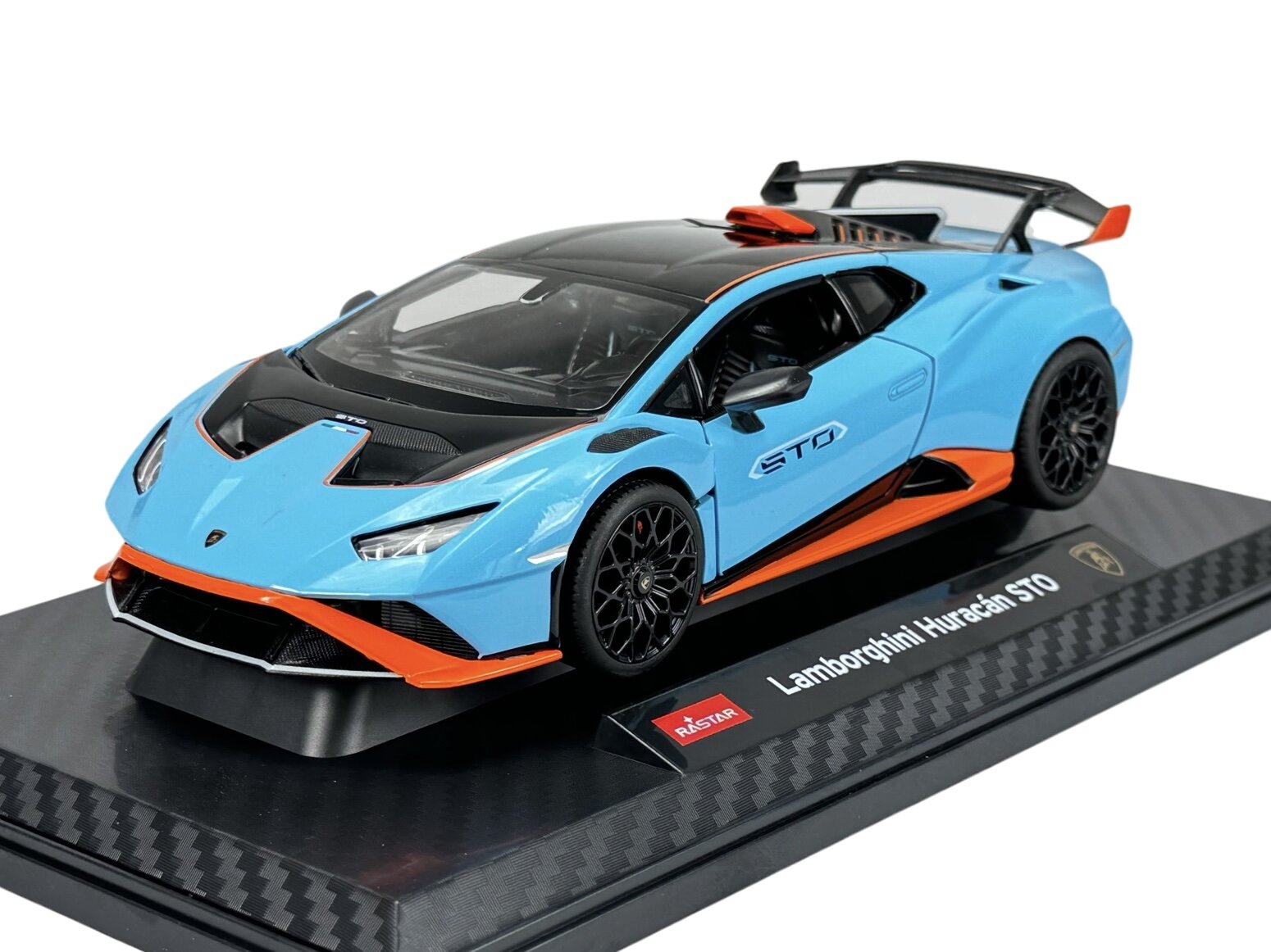 Model samochodu w kolorze niebieskim z czarnymi i pomarańczowymi akcentami, umieszczony na podstawce z napisem \'Lamborghini Huracan STO\'. Widoczne logo \'Rastar\'.
