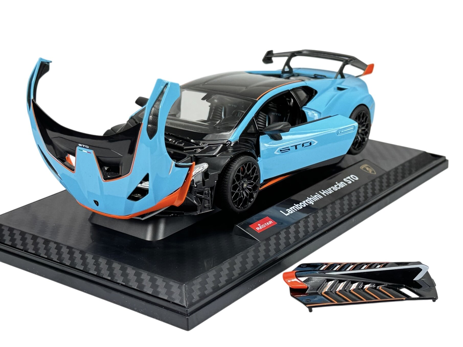 Model samochodu w kolorze niebieskim z czarnymi i pomarańczowymi elementami, z otwartą maską i widocznym wnętrzem. Na podstawce znajduje się napis \'Lamborghini Huracan STO\' oraz logo producenta \'Rastar\'.
