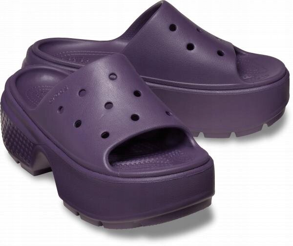 Fioletowe klapki na platformie z otworami na górze i teksturą na podeszwie. Na jednym z butów widoczne jest logo \'Crocs\'.