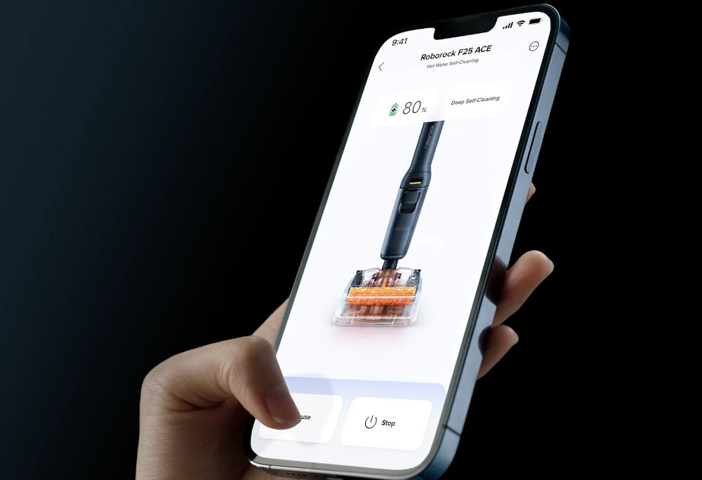 Osoba trzyma smartfon z aplikacją pokazującą odkurzacz mopujący Roborock F25 ACE. Na ekranie widoczny jest poziom naładowania 80% oraz przyciski \'Pause\' i \'Stop\'.