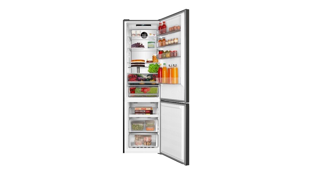 Otwarta lodówka z widocznymi półkami wypełnionymi różnorodnymi produktami spożywczymi, takimi jak napoje, owoce, warzywa i ciasta. W dolnej części znajdują się przezroczyste szuflady z mrożonkami.