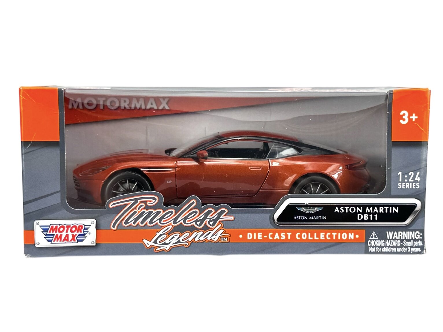Model samochodu Aston Martin DB11 w kolorze pomarańczowym znajduje się w opakowaniu z napisem \'Timeless Legends\' oraz \'Motormax\'. Na opakowaniu widnieje informacja \'1:24 Series\' oraz ostrzeżenie \'WARNING: CHOKING HAZARD - Small parts. Not for children under 3 years.\'