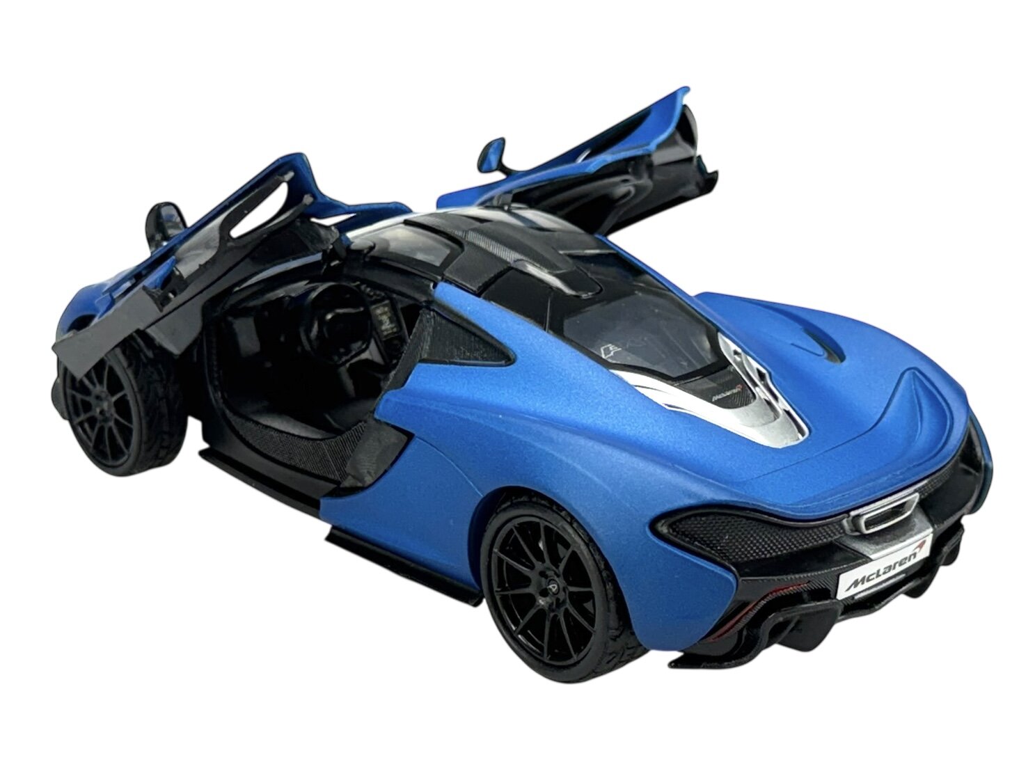 Model samochodu w kolorze niebieskim matowym z otwartymi drzwiami i widocznym wnętrzem. Na tablicy rejestracyjnej widnieje napis \'McLaren\'.