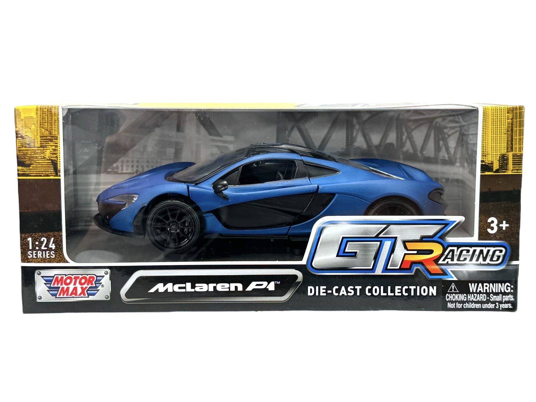 Model samochodu w skali 1:24 w kolorze niebieskim matowym, zapakowany w pudełko z przezroczystym frontem. Na opakowaniu widoczne są napisy: \'Motor Max\', \'McLaren P1\', \'GT Racing\', \'Die-Cast Collection\' oraz ostrzeżenie o małych częściach.