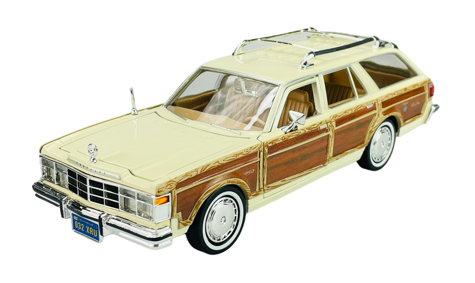 Model samochodu w kolorze beżowym z drewnianymi panelami na bokach, przedstawiający Chrysler Lebaron Town & Country z 1979 roku. Na tablicy rejestracyjnej widnieje napis \'032 XRU\'.