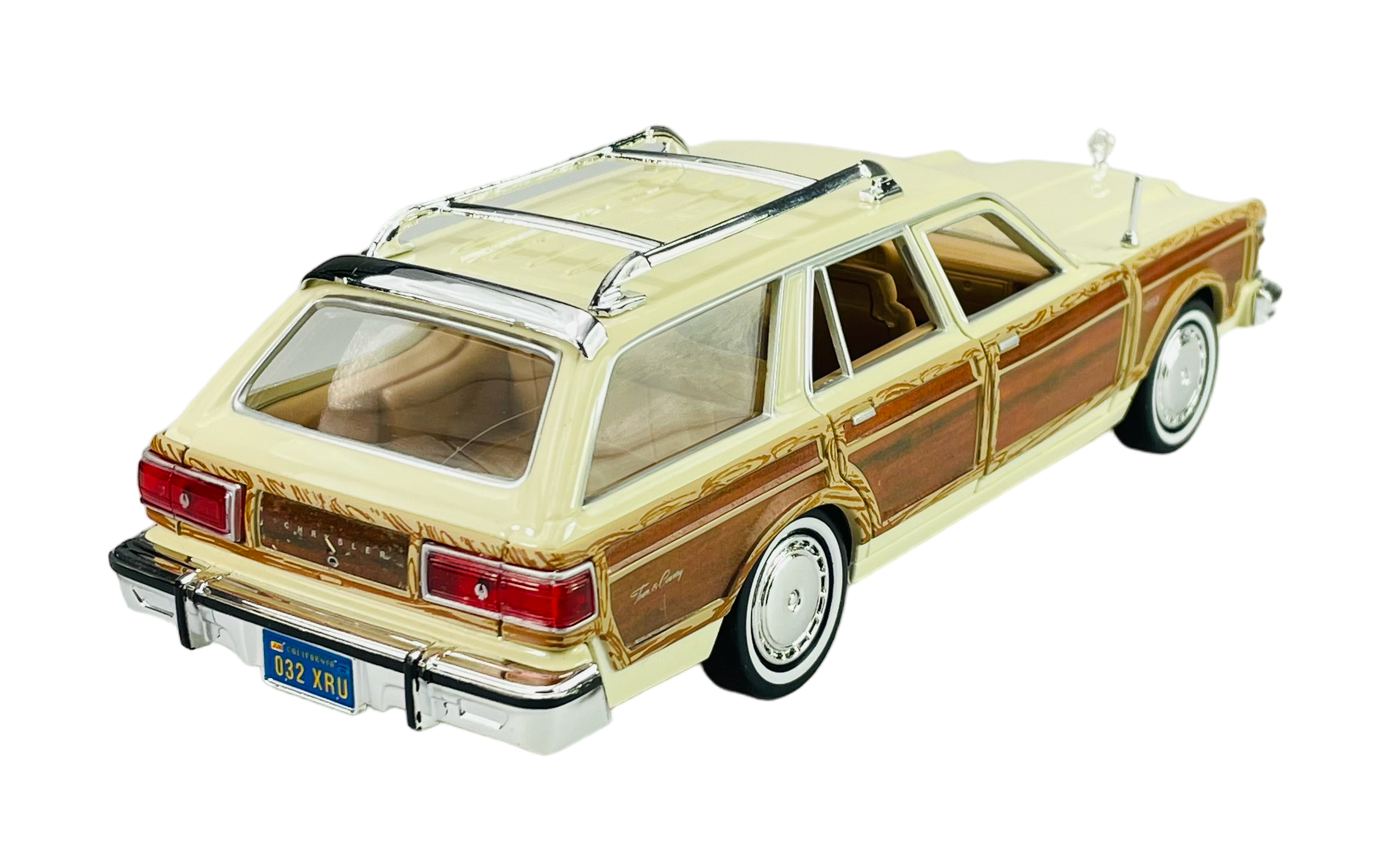 Model samochodu w kolorze beżowym z drewnianymi panelami po bokach, przedstawiający Chrysler Lebaron Town & Country. Na tablicy rejestracyjnej widnieje napis \'032 XRU\'.