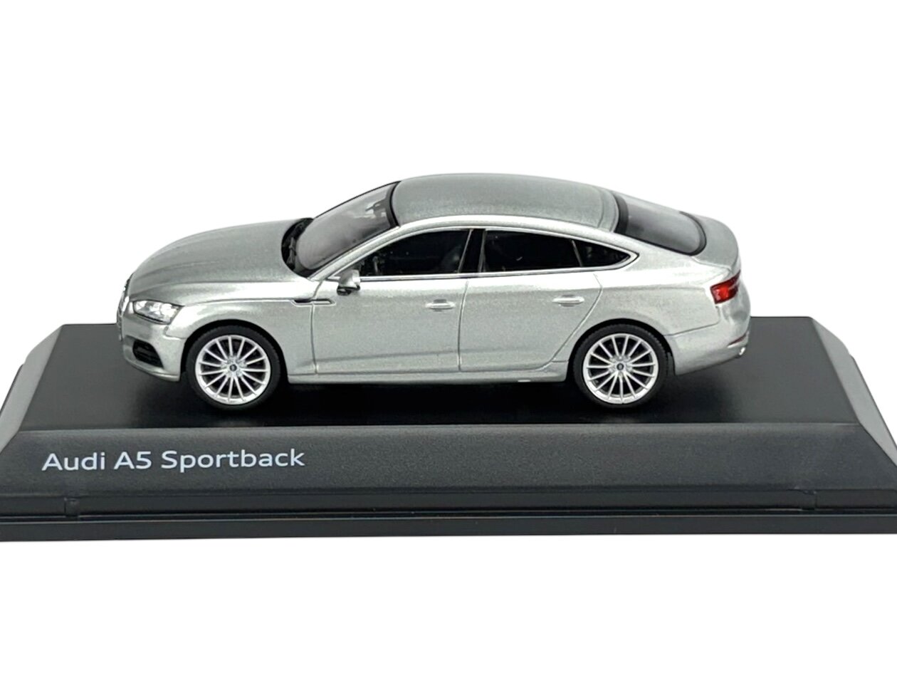 Model samochodu Audi A5 Sportback w kolorze srebrnym, umieszczony na czarnej podstawce z napisem \'Audi A5 Sportback\'.
