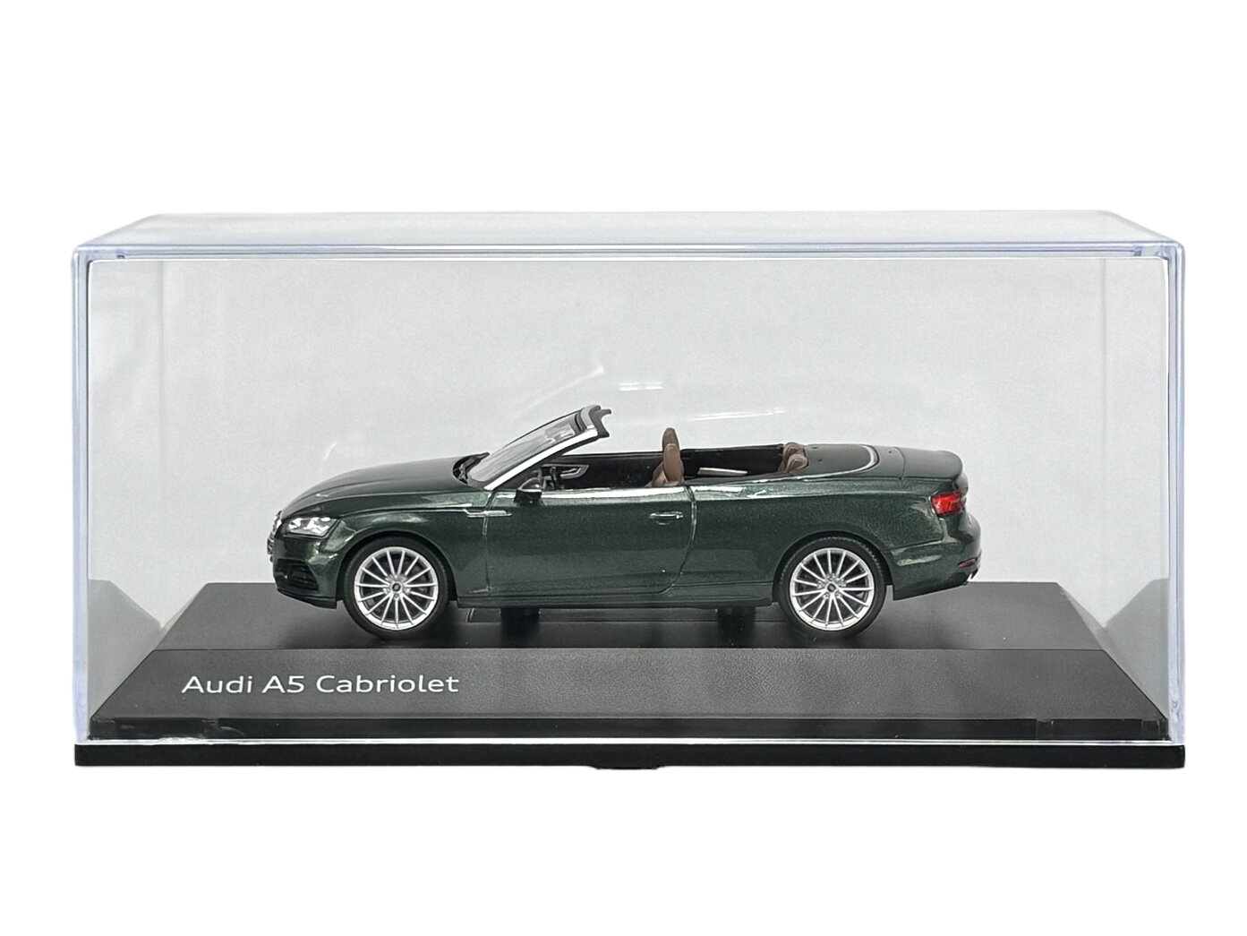 Model samochodu Audi A5 Cabriolet w kolorze ciemnozielonym, umieszczony w przezroczystej gablocie. Na podstawce widoczny jest napis \'Audi A5 Cabriolet\'.