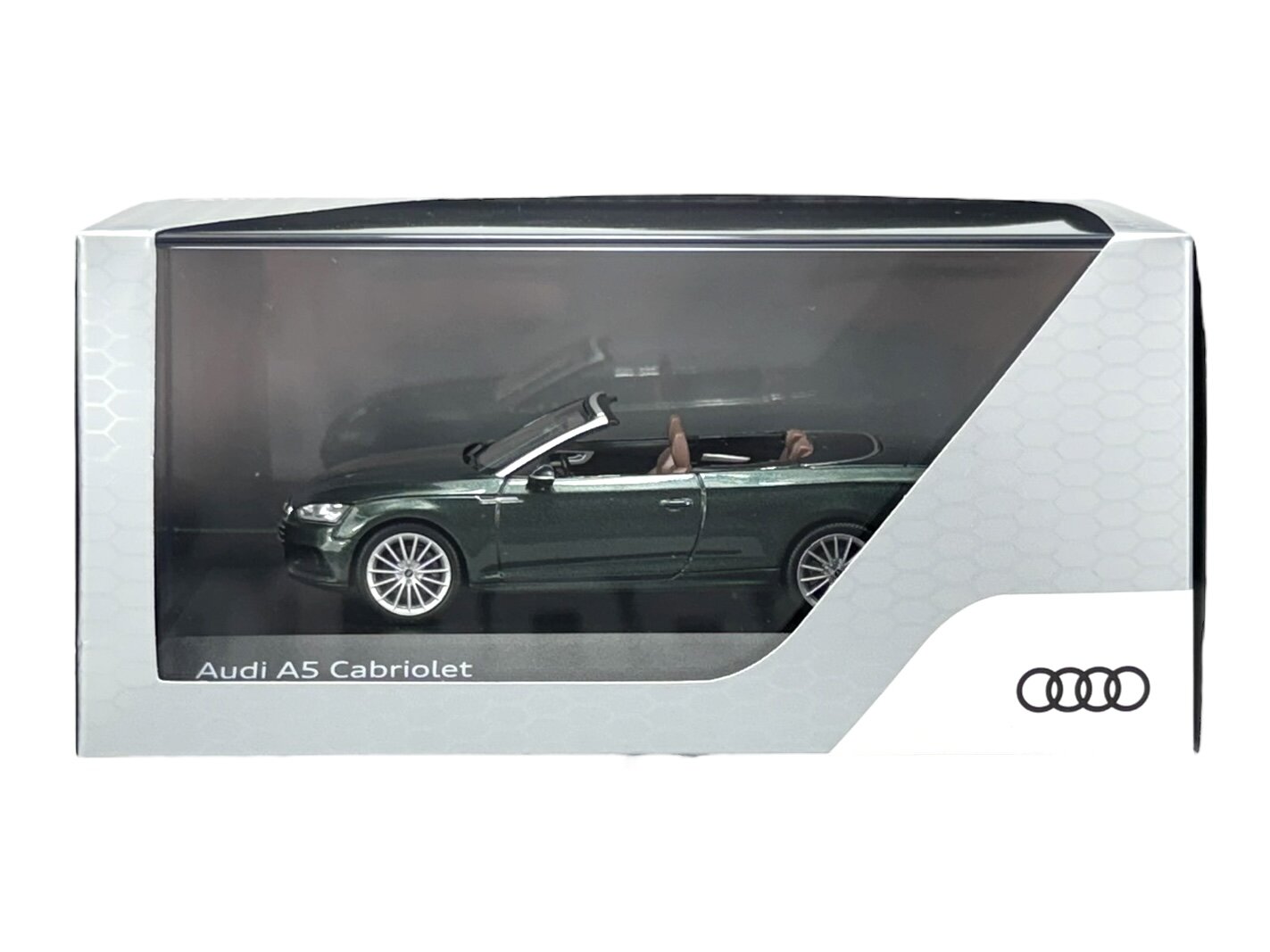 Model samochodu Audi A5 Cabriolet w kolorze zielonym znajduje się w przezroczystym opakowaniu. Na opakowaniu widoczne jest logo Audi oraz napis \'Audi A5 Cabriolet\'.