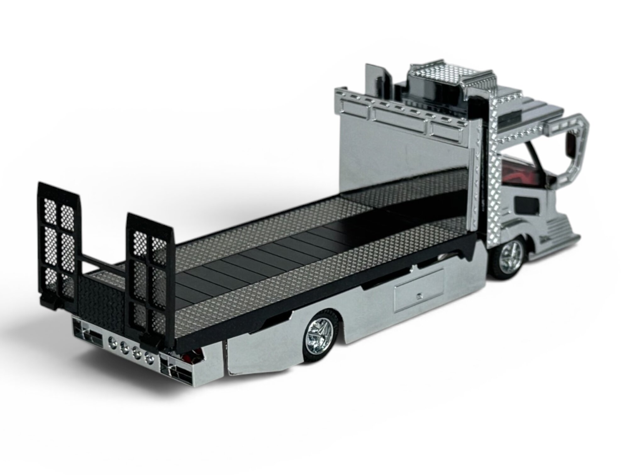 Model metalowej lawety w skali 1:64 z detalami w kolorze srebrnym i czarnym. Posiada realistyczne elementy, takie jak kratki i reflektory.