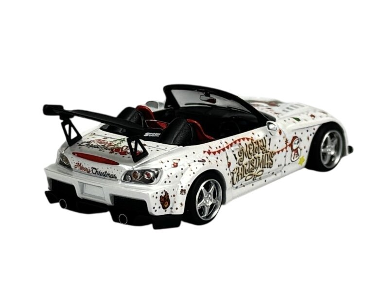 Model samochodu w skali 1:64, ozdobiony świątecznymi grafikami i napisami \'Merry Christmas\'. Posiada białe nadwozie z czarnym spojlerem i srebrnymi felgami.