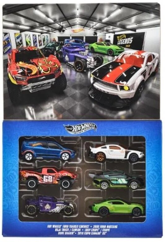 Obraz przedstawia zestaw sześciu metalowych modeli samochodów Hot Wheels w opakowaniu z przezroczystym frontem. W tle widoczna jest grafika z większymi modelami samochodów w pomieszczeniu wystawowym z logo \'Legends Tour\'.