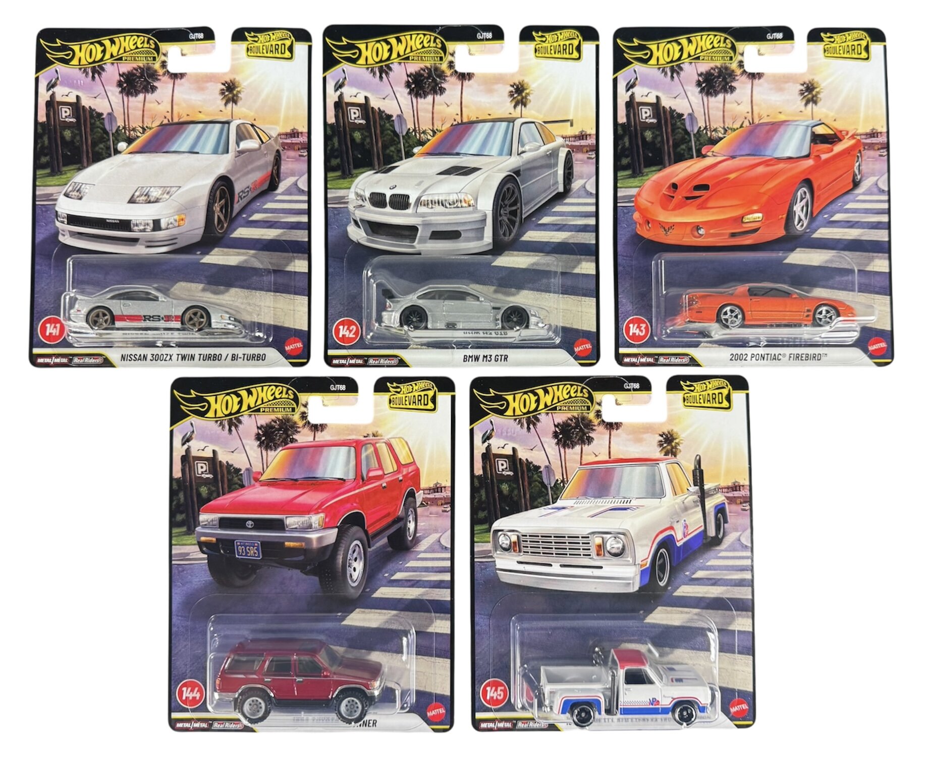 Zestaw pięciu metalowych modeli samochodów Hot Wheels Premium Boulevard, w tym Nissan 300ZX Twin Turbo, BMW M3 GTR, 2002 Pontiac Firebird, Jeep Grand Cherokee i ciężarówka z napisem \'Hot Wheels\'. Każdy model jest zapakowany w osobne opakowanie z grafiką przedstawiającą samochód na tle miejskiego krajobrazu.