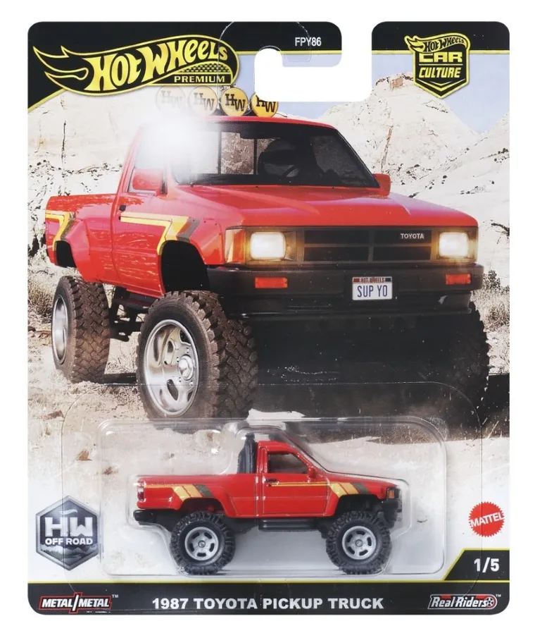 Opakowanie z modelem samochodu Hot Wheels Premium, przedstawiające czerwony pickup z napisem \'1987 Toyota Pickup Truck\'. Widoczne są loga \'HW Off Road\', \'Metal/Metal\' oraz \'Mattel\'.