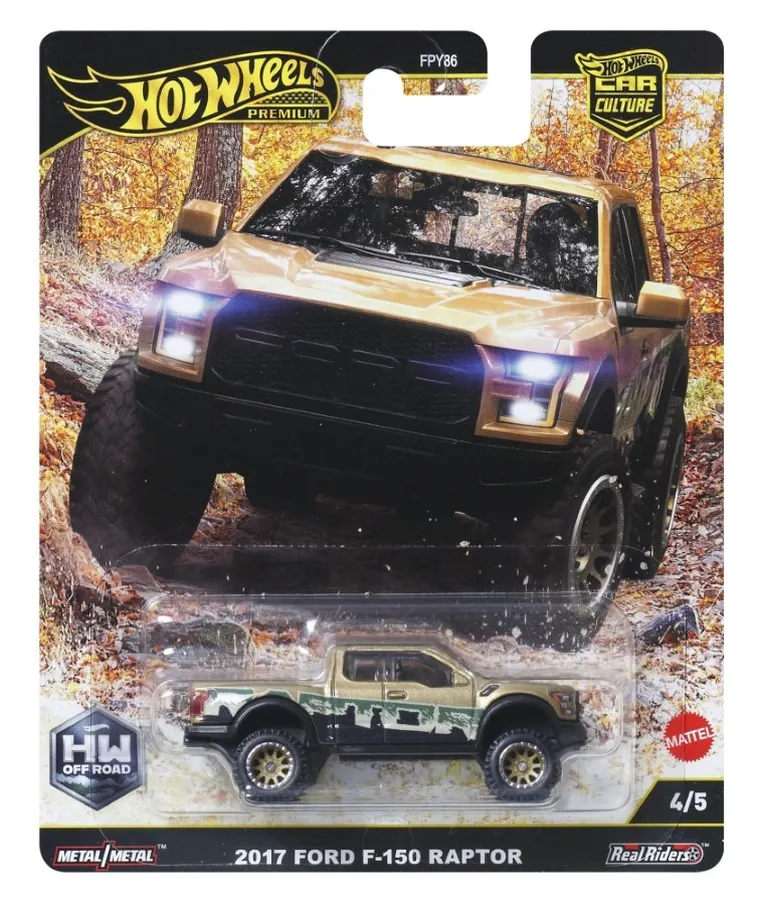 Opakowanie z modelem samochodu Hot Wheels Premium, przedstawiające 2017 Ford F-150 Raptor w kolorze złoto-zielonym. Na opakowaniu widoczne są napisy: \'Hot Wheels Premium\', \'HW Off Road\', \'2017 Ford F-150 Raptor\', \'Metal/Metal\', \'Real Riders\', oraz logo Mattel.
