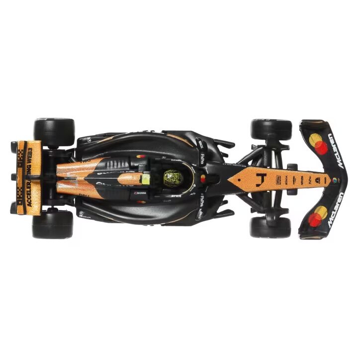 Model samochodu wyścigowego w kolorach czarnym i pomarańczowym z widocznymi logotypami \'McLaren\' i \'Accelerating Transformation\'.