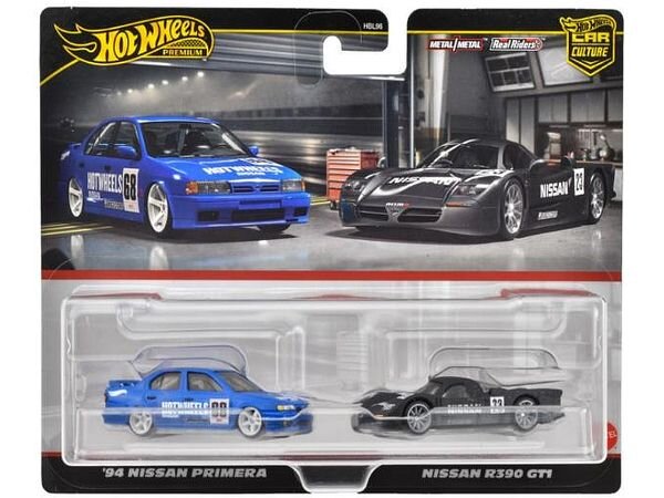 Opakowanie z dwoma modelami samochodów Hot Wheels Premium: niebieskim \'94 Nissan Primera i czarnym Nissan R390 GT1. Na opakowaniu widoczne są napisy: \'Hot Wheels Premium\', \'Metal/Metal\', \'Real Riders\', \'Car Culture\'.