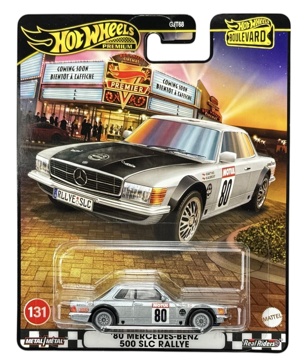 Opakowanie z modelem samochodu \'80 Mercedes-Benz 500 SLC Rallye w skali, z widocznym logo Hot Wheels Premium. Na tle znajduje się ilustracja samochodu przed kinem z napisami \'COMING SOON BIENTOT A L\'AFFICHE\'.