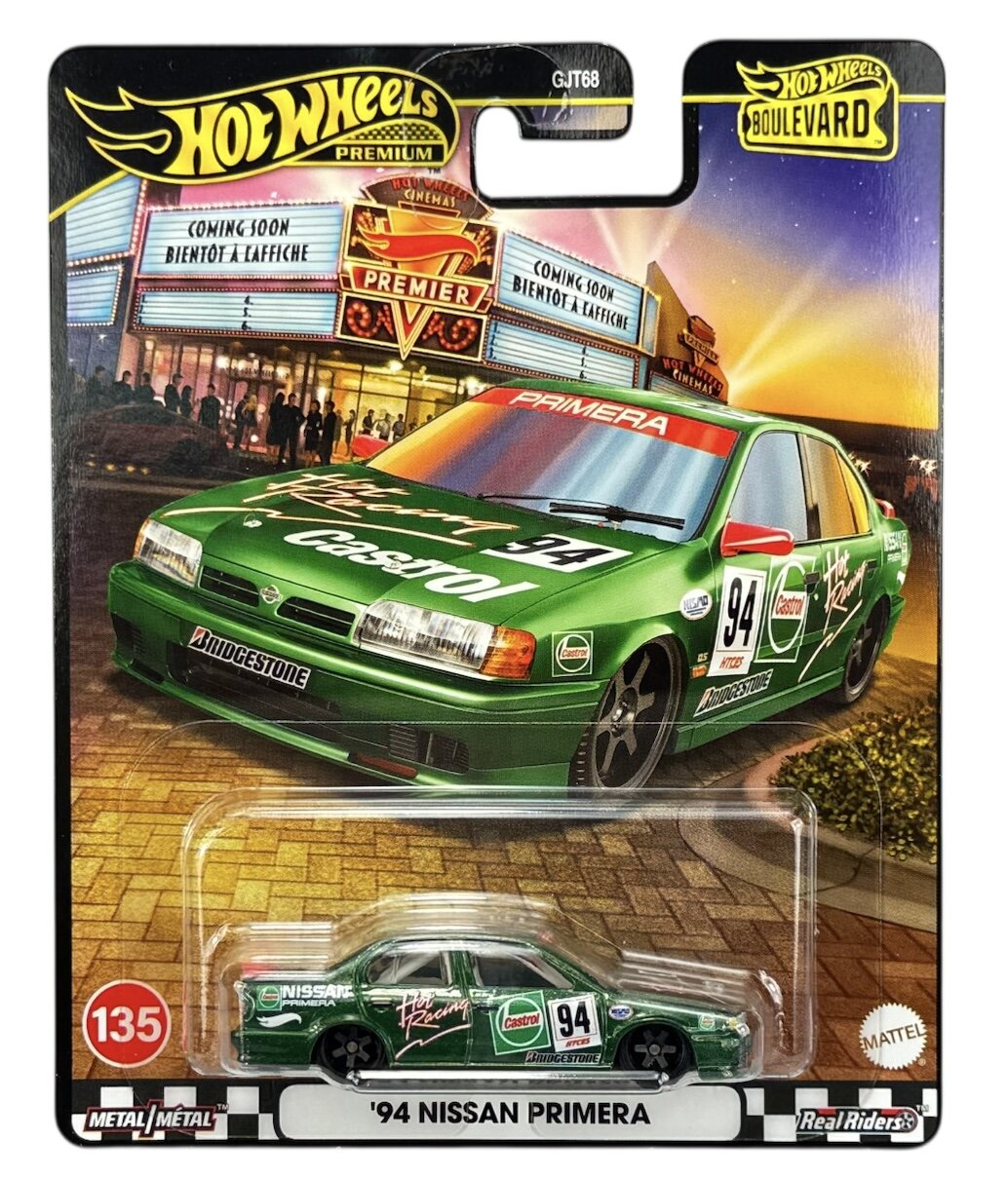 Opakowanie z modelem samochodu \'94 Nissan Primera w zielonym kolorze z nadrukami reklamowymi, w tym \'Castrol\' i \'Bridgestone\'. Na górze widoczne logo \'Hot Wheels Premium\' oraz napis \'Boulevard\'.