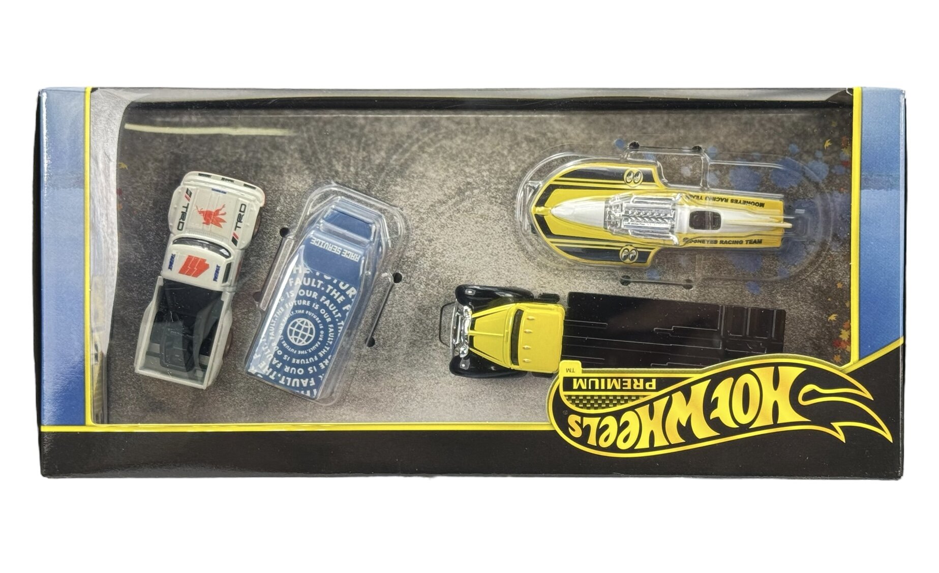 Zestaw czterech metalowych modeli samochodów Hot Wheels Premium w opakowaniu z logo \'Hot Wheels\'. Modele mają różne kolory i wzory, w tym biały, niebieski i żółty.