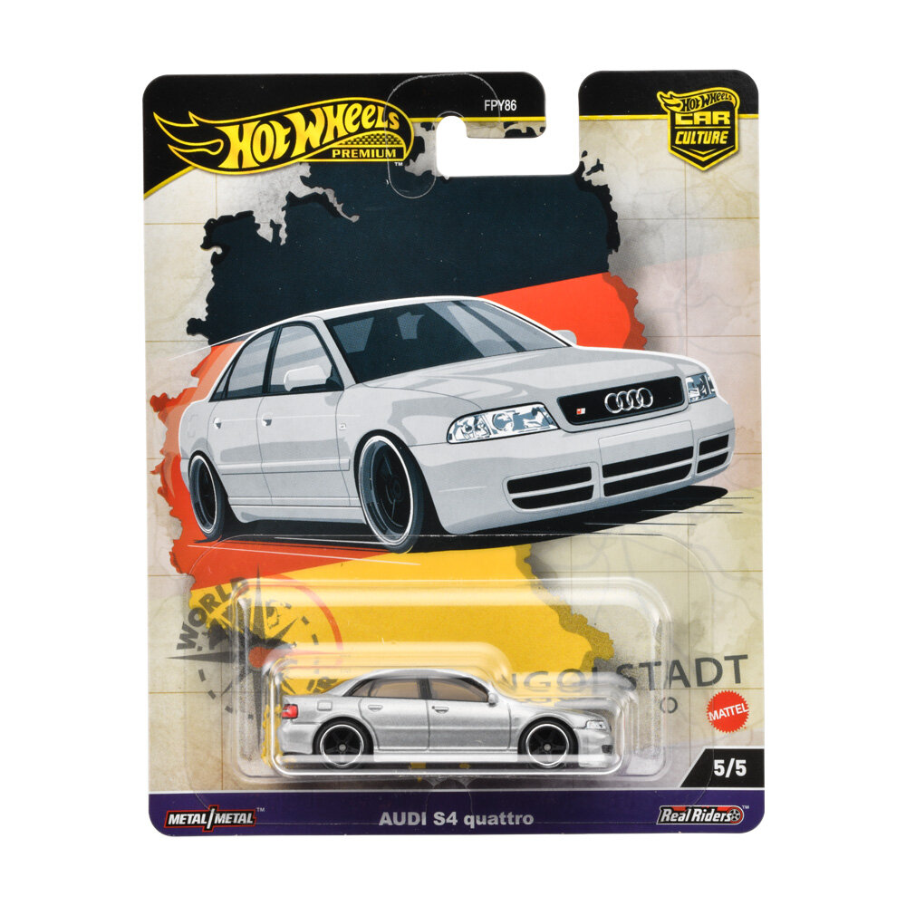 Opakowanie z modelem samochodu Hot Wheels Premium, przedstawiające biały samochód Audi S4 quattro na tle mapy. Widoczny tekst: \'Hot Wheels Premium\', \'FPY86\', \'AUDI S4 quattro\', \'5/5\', \'Metal/Metal\', \'Real Riders\', \'Mattel\'.