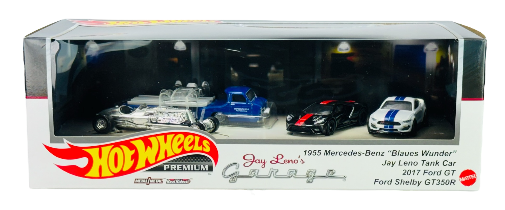 Zestaw Hot Wheels Premium Jay Leno\'s Garage zawiera cztery metalowe modele samochodów w opakowaniu z przezroczystym frontem. Na opakowaniu widnieje tekst: \'1955 Mercedes-Benz \'Blaues Wunder\', Jay Leno Tank Car, 2017 Ford GT, Ford Shelby GT350R\'.
