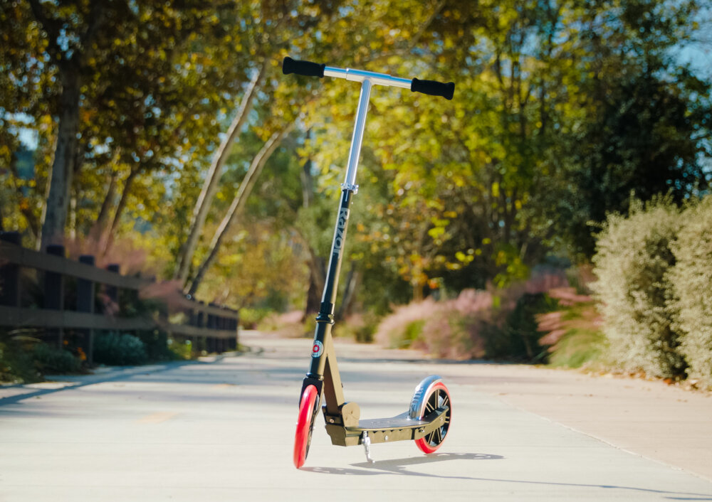Hulajnoga RAZOR Carbon Lux 13073003 Czarny chłopak jedzie na hulajnodze po drodze rowerowej pasja zabawa rozwój uniwersalność funkcjonalność