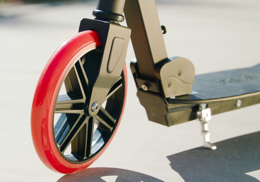 Hulajnoga RAZOR Carbon Lux 13073003 Czarny zbliżenie na przednie koło uretanowe koła z łożyskami ABEC-5 płynna jazda trwałość średnica 200 mm stabilna jazda łatwe manewrowanie odporne na ścieranie i dobrze tłumią wstrząsy