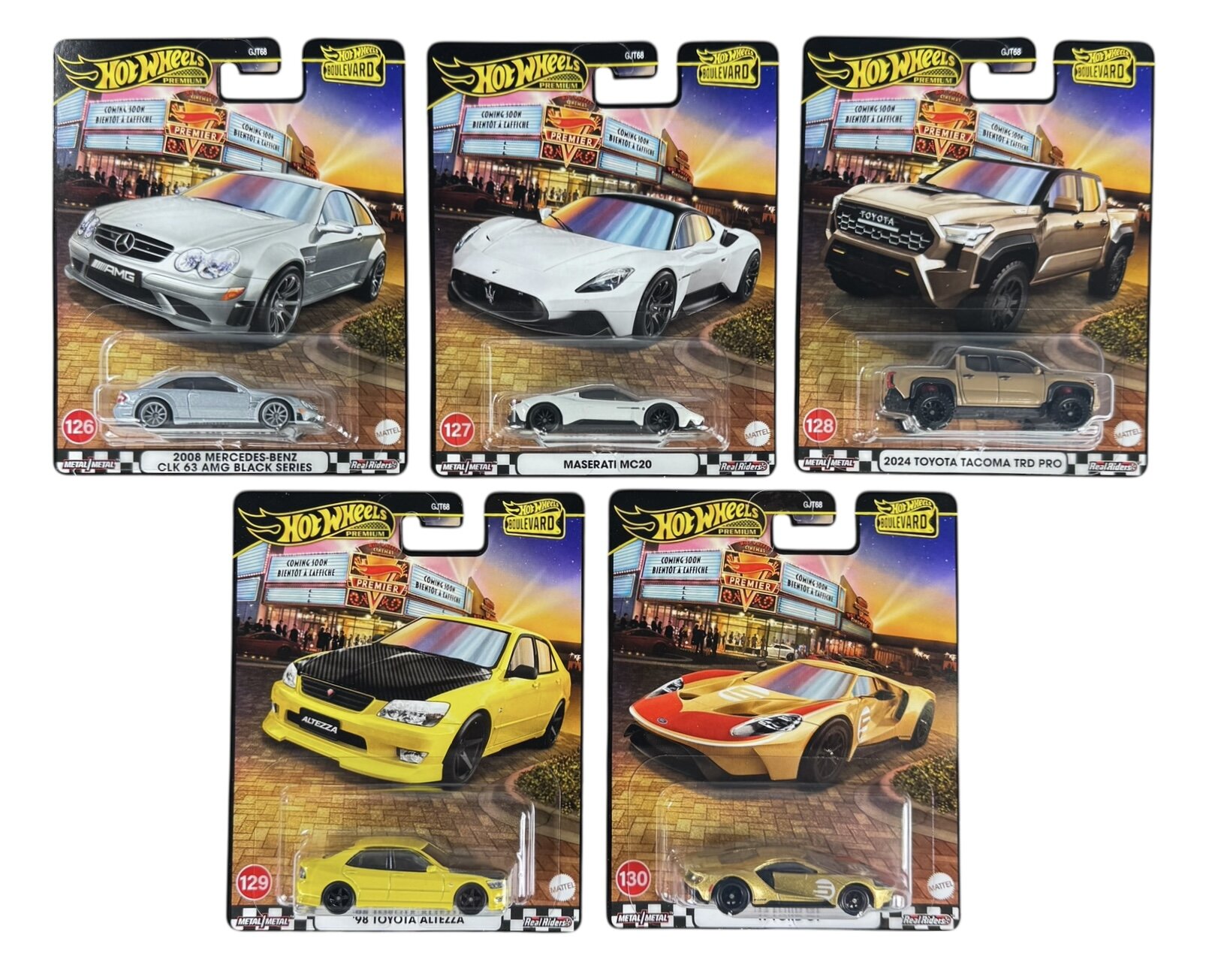 Na obrazie widoczne są pięć opakowań modeli samochodów Hot Wheels Premium Boulevard. Każde opakowanie zawiera metalowy model samochodu z nazwą: 2006 Mercedes-Benz CLK DTM AMG, Maserati MC20, 2024 Toyota Tacoma TRD Pro, \'98 Toyota Altezza, Ford GT Race.