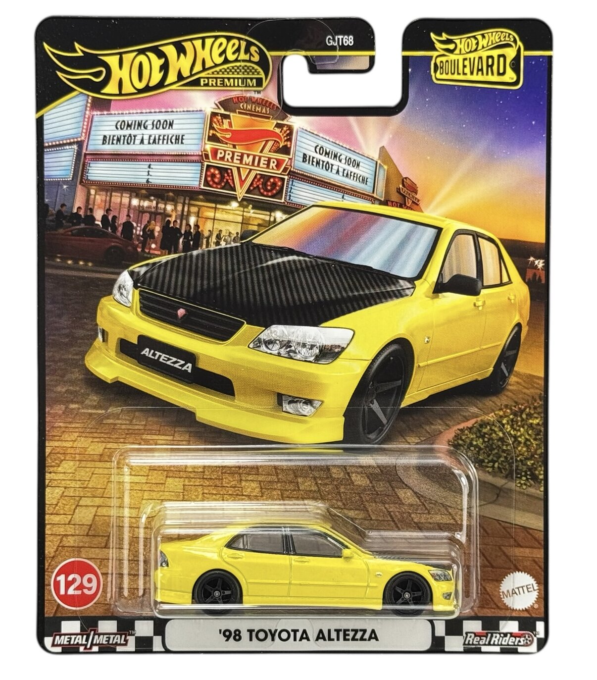 Opakowanie z modelem samochodu Hot Wheels Premium przedstawiające żółty samochód \'98 Toyota Altezza. Na opakowaniu widnieje napis \'COMING SOON BIENTOT A L\'AFFICHE\' oraz logo Hot Wheels Boulevard.
