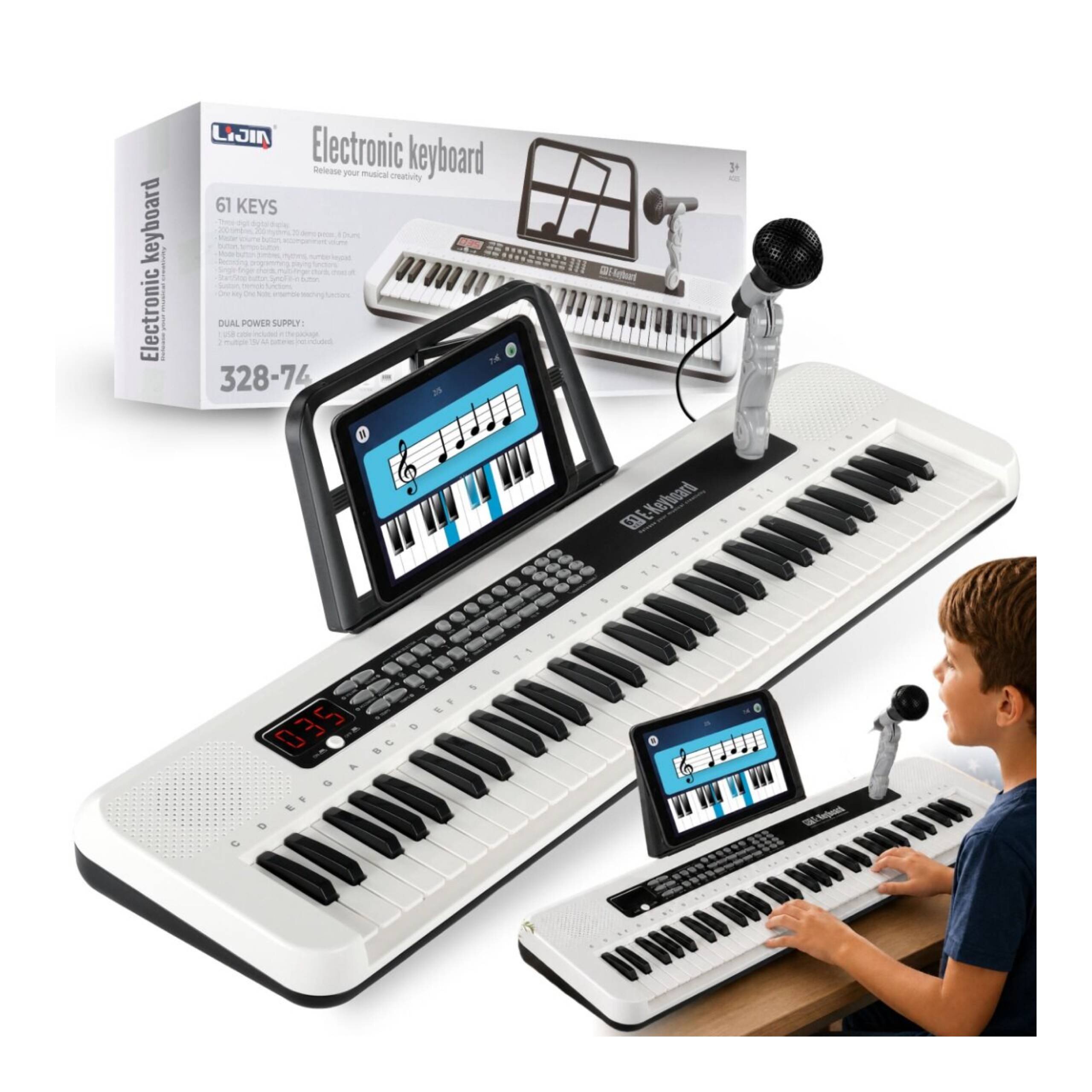 Na obrazie widoczny jest biały keyboard z 61 klawiszami, stojak na nuty z tabletem oraz mikrofon. W tle znajduje się pudełko z napisem \'Electronic keyboard\' i logo producenta.