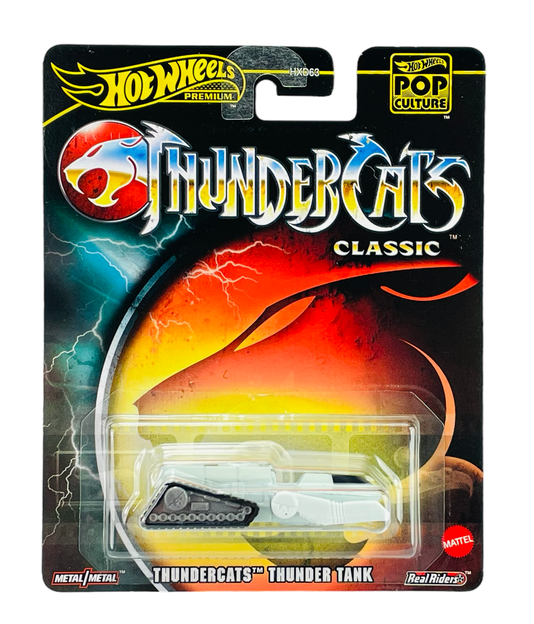 Opakowanie z zabawką Hot Wheels Premium z serii Pop Culture, przedstawiające model ThunderCats Thunder Tank. Na opakowaniu widoczne są napisy: \'ThunderCats Classic\', \'Metal/Metal\', \'Real Riders\' oraz logo Mattel.