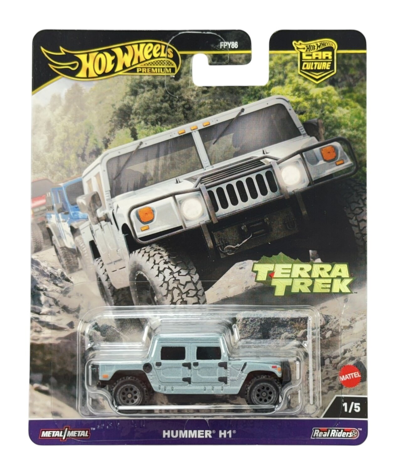 Opakowanie z modelem samochodu Hot Wheels Premium, przedstawiające pojazd Hummer H1 w kolorze srebrnym. Na opakowaniu widoczne są napisy: \'Terra Trek\', \'HUMMER H1\', \'Metal/Metal\', \'Real Riders\', oraz logo Mattel.