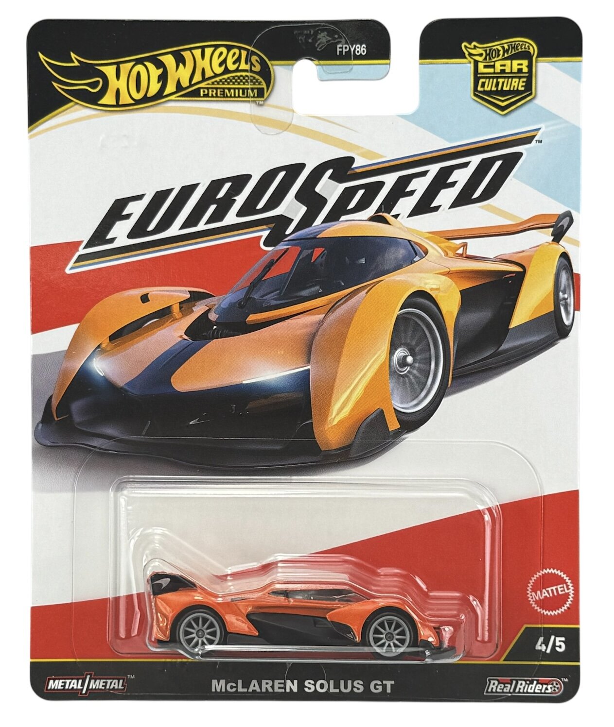Opakowanie z modelem samochodu Hot Wheels Premium z serii Eurospeed, przedstawiające pomarańczowy samochód McLaren Solus GT. Widoczne są napisy: \'Hot Wheels Premium\', \'Eurospeed\', \'McLaren Solus GT\', \'Metal/Metal\', \'Real Riders\', \'Mattel\'.