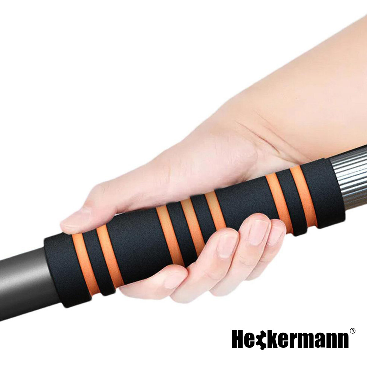 Osoba trzyma uchwyt szczotki z czarno-pomarańczowymi paskami. W prawym dolnym rogu widoczne jest logo \'Heckermann\'.