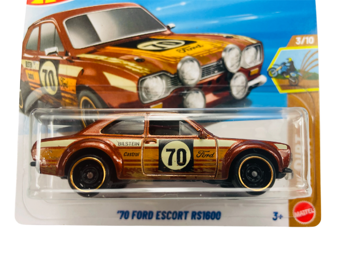 Opakowanie z modelem samochodu \'70 Ford Escort RS1600 w kolorze brązowym z numerem 70 na drzwiach. Widoczny tekst: \'70 Ford Escort RS1600\', \'Bilstein\', \'Castrol\', \'3+\', \'Mattel\'.