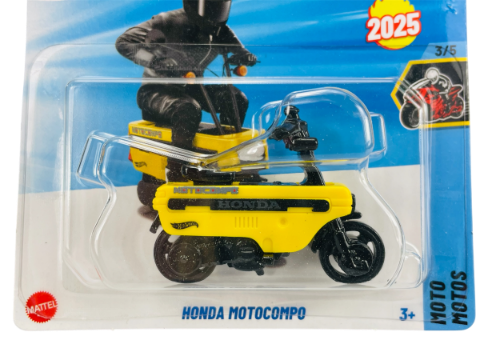 Opakowanie z metalowym modelem motocykla Honda Motocompo w kolorze żółtym. Na opakowaniu widoczny jest napis \'2025\', logo \'Mattel\' oraz tekst \'HONDA MOTOCOMPO\'.