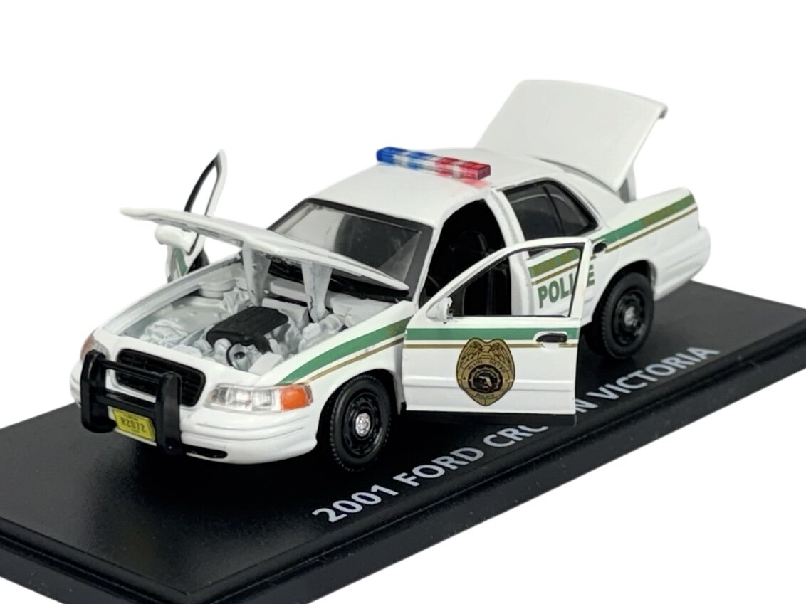 Model policyjnego samochodu Ford Crown Victoria z 2001 roku w skali 1:43, z otwartymi drzwiami i maską, umieszczony na podstawce z napisem \'2001 FORD CROWN VICTORIA\'.