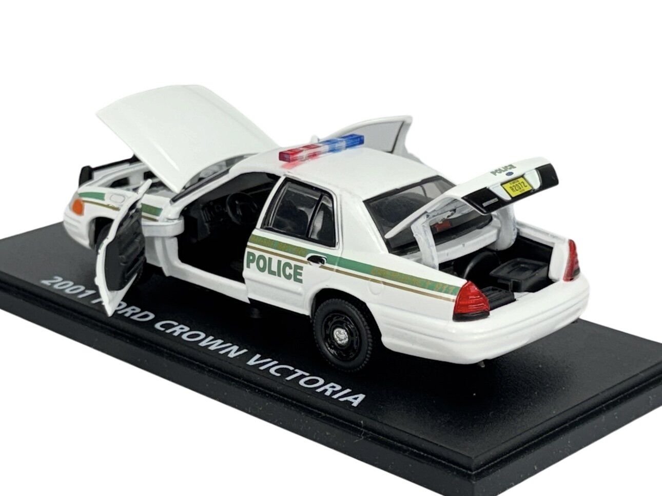 Model samochodu policyjnego 2001 Ford Crown Victoria z otwartymi drzwiami, maską i bagażnikiem, umieszczony na podstawce z napisem \'2001 FORD CROWN VICTORIA\'.