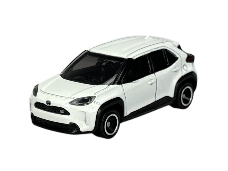 Biały model samochodu o nowoczesnym designie z czarnymi detalami i logo Toyota na przodzie. Model jest metalowy i szczegółowo odwzorowuje rzeczywisty pojazd.